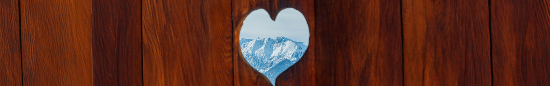 Vue sur les montagnes à travers un cœur en bois